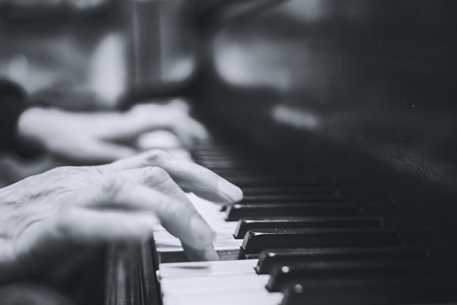 Músico talentoso tocando um piano de cauda em uma sala iluminada