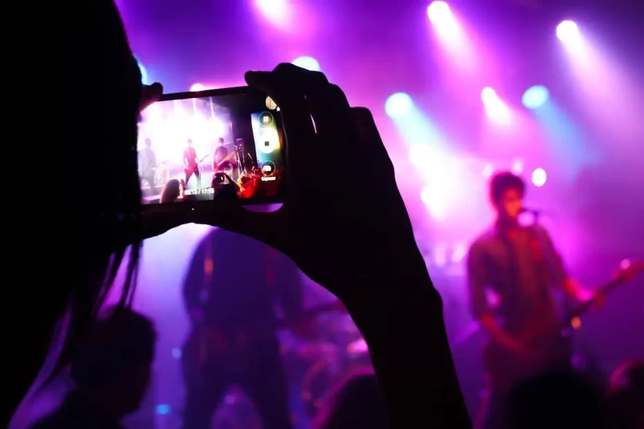 Um guitarrista em um momento épico no palco, iluminado por uma aura de luz, derramando sua paixão e energia na guitarra, enquanto a multidão se deleita com o som vibrante e arrebatador do rock.